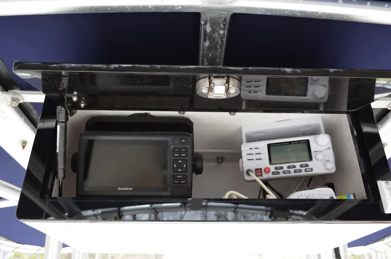 Slide: The Image of 2018 Robalo R200 Center Console electronics compartment with Garmin and radio equipment. - 38