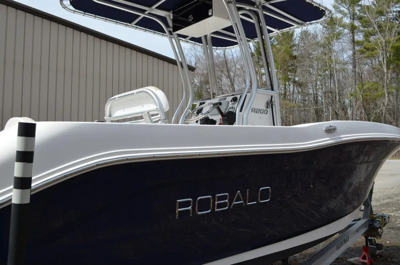 Slide: The Image of 2018 Robalo R200 Center Console boat with sleek design, parked outdoors. - 47