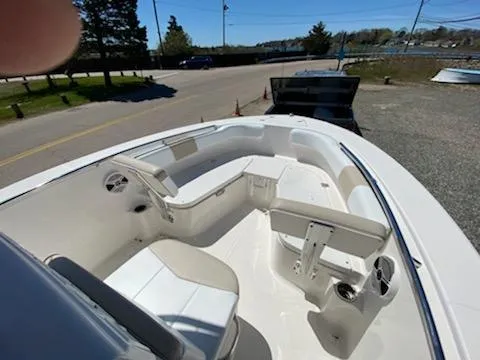 Slide: The Image of 2018 Robalo R200 Center Console boat interior with seating and console, parked near a road. - 8