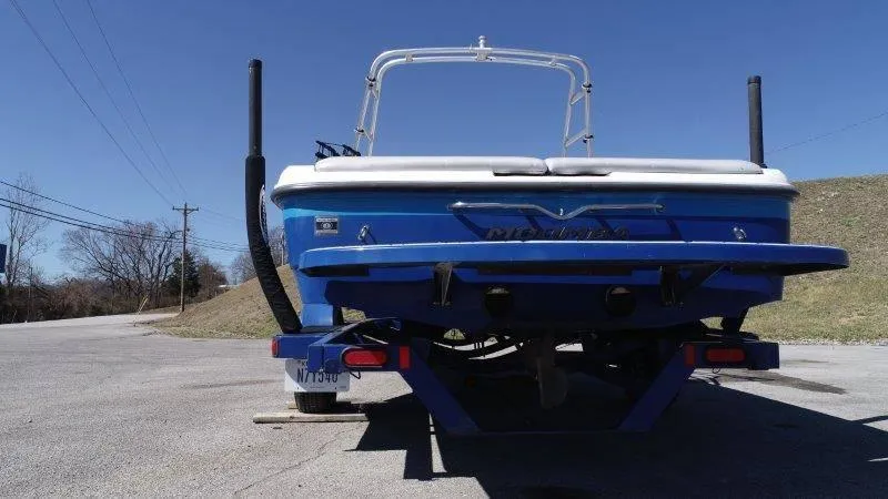 Slide: The Image of 2009 Moomba Outback SK boat, blue, rear view, parked on a trailer, clear sky background. - 13
