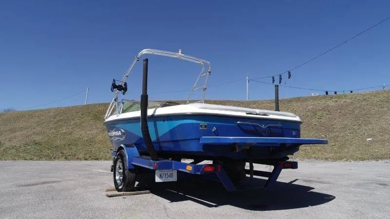 Slide: The Image of 2009 Moomba Outback SK boat on trailer, parked outdoors under clear blue sky. - 17