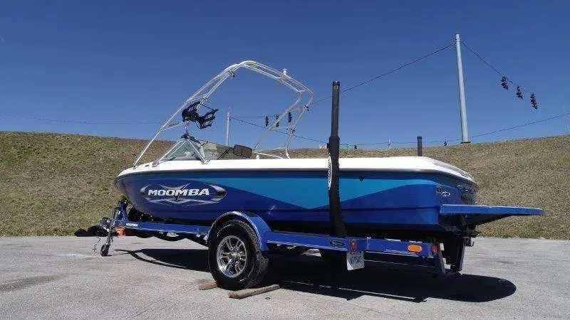 Slide: The Image of 2009 Moomba Outback SK boat on trailer, blue and white design, parked outdoors. - 18