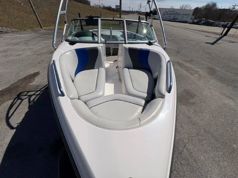 Slide: The Image of 2009 Moomba Outback SK boat with white and blue interior, parked on pavement. - 27