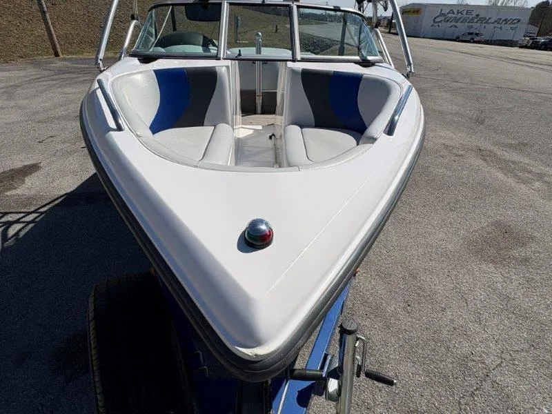 Slide: The Image of 2009 Moomba Outback SK boat with white and blue interior, parked on pavement. - 31