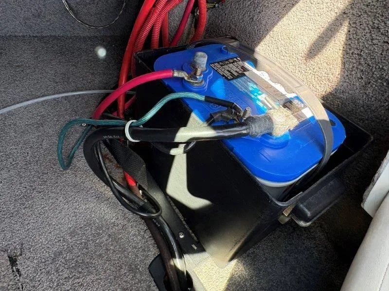 Slide: The Image of 2009 Moomba Outback SK boat battery with red and black cables in compartment. - 45