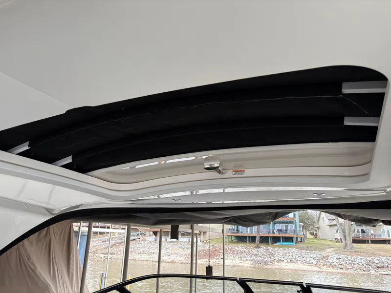 Slide: The Image of 2017 Sea Ray SLX 310 boat interior with open sunroof, dockside view. - 13