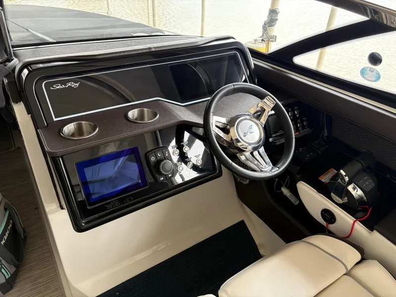 Slide: The Image of 2017 Sea Ray SLX 310 helm with steering wheel, controls, and display screen. - 21