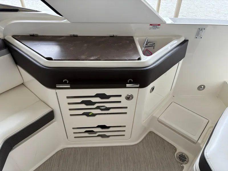Slide: The Image of 2017 Sea Ray SLX 310 boat interior with storage and seating area. - 31