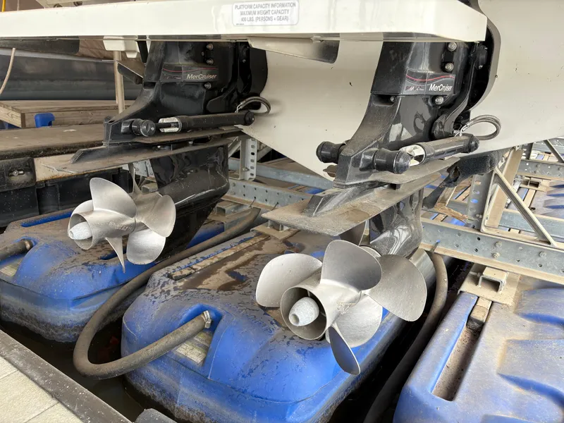 Slide: The Image of 2017 Sea Ray SLX 310 boat propellers on blue supports in a maintenance area. - 32