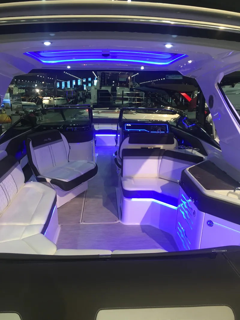 Slide: The Image of 2017 Sea Ray SLX 310 boat interior with blue LED lighting and luxurious seating. - 34