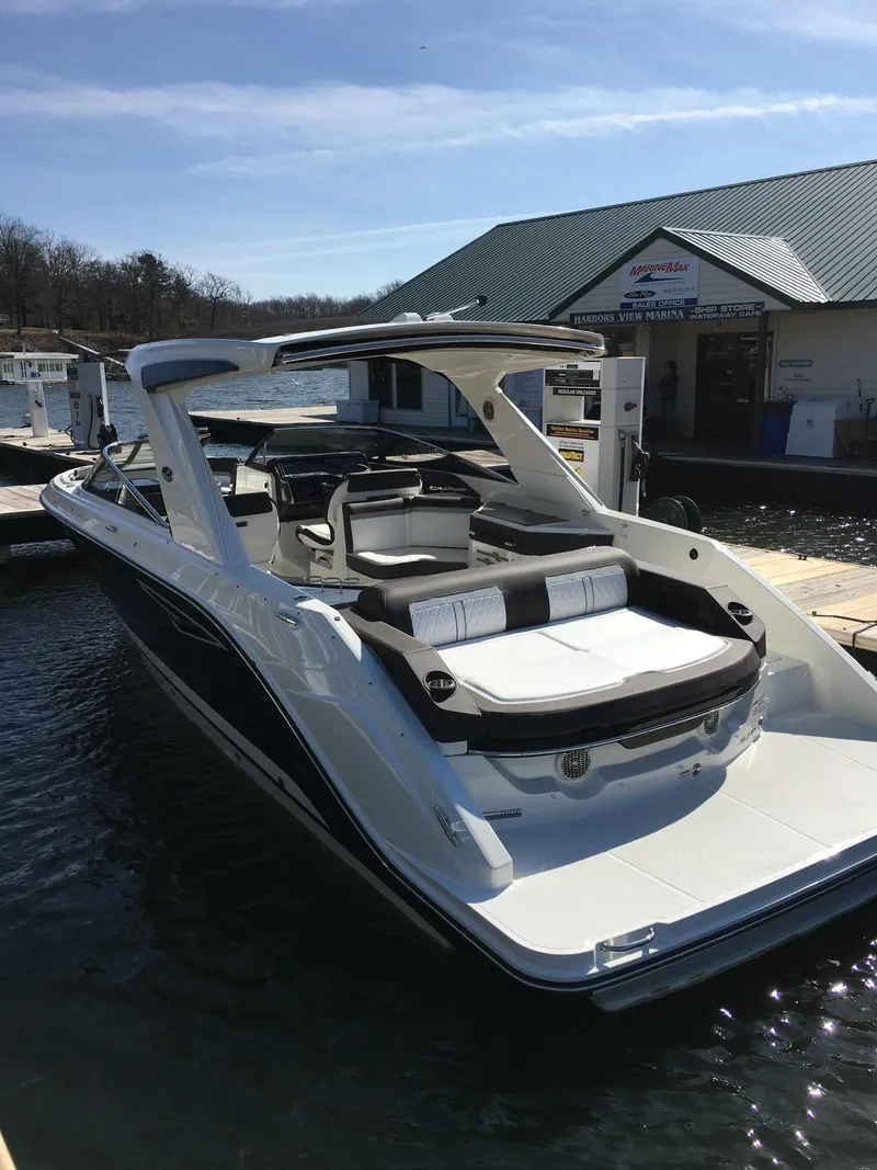 Slide: The Image of 2017 Sea Ray SLX 310 boat docked at marina under clear sky. - 35