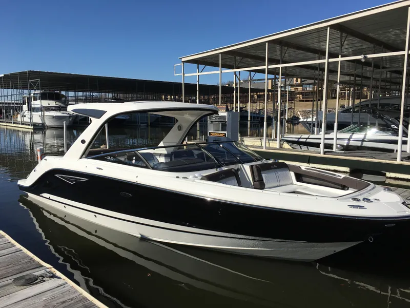 Slide: The Image of 2017 Sea Ray SLX 310 boat docked at marina under clear blue sky. - 38