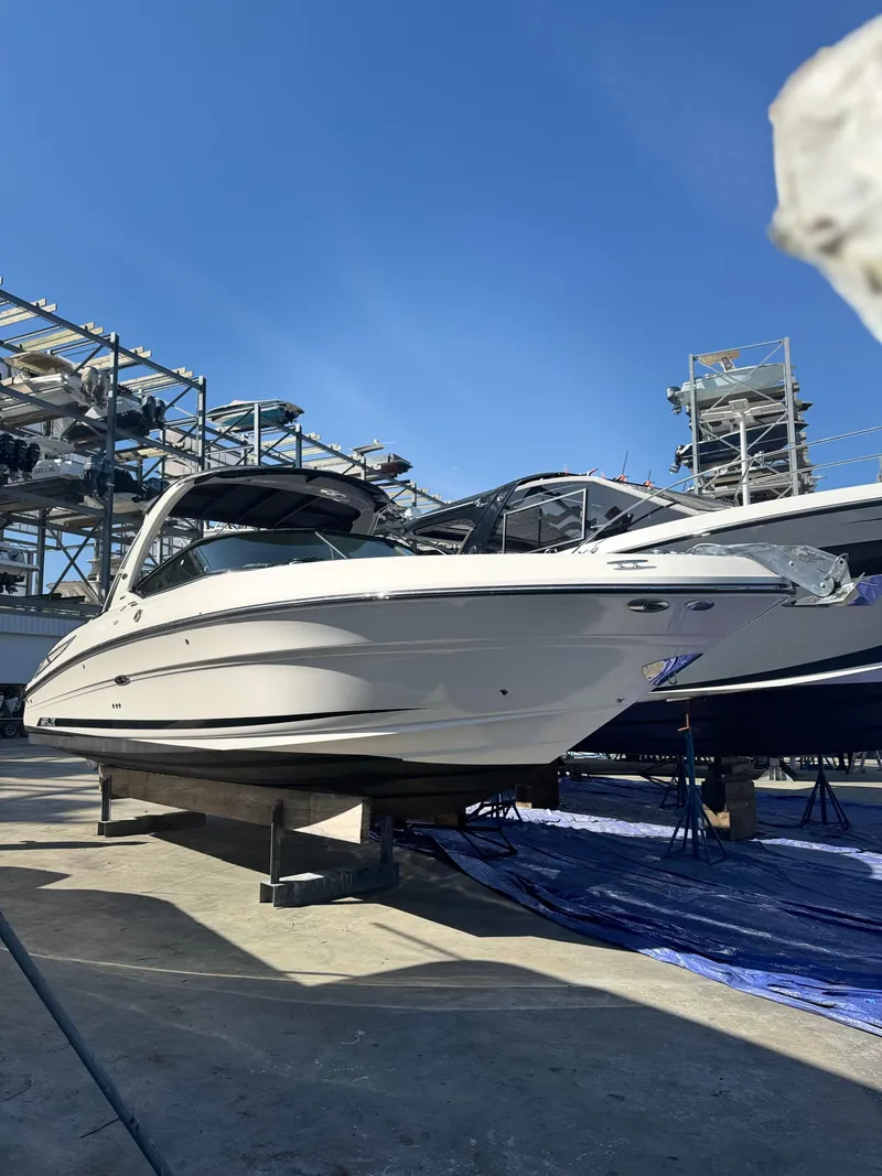Slide: The Image of 2014 Sea Ray 300 SLX boat on dry dock under clear blue sky. - 1