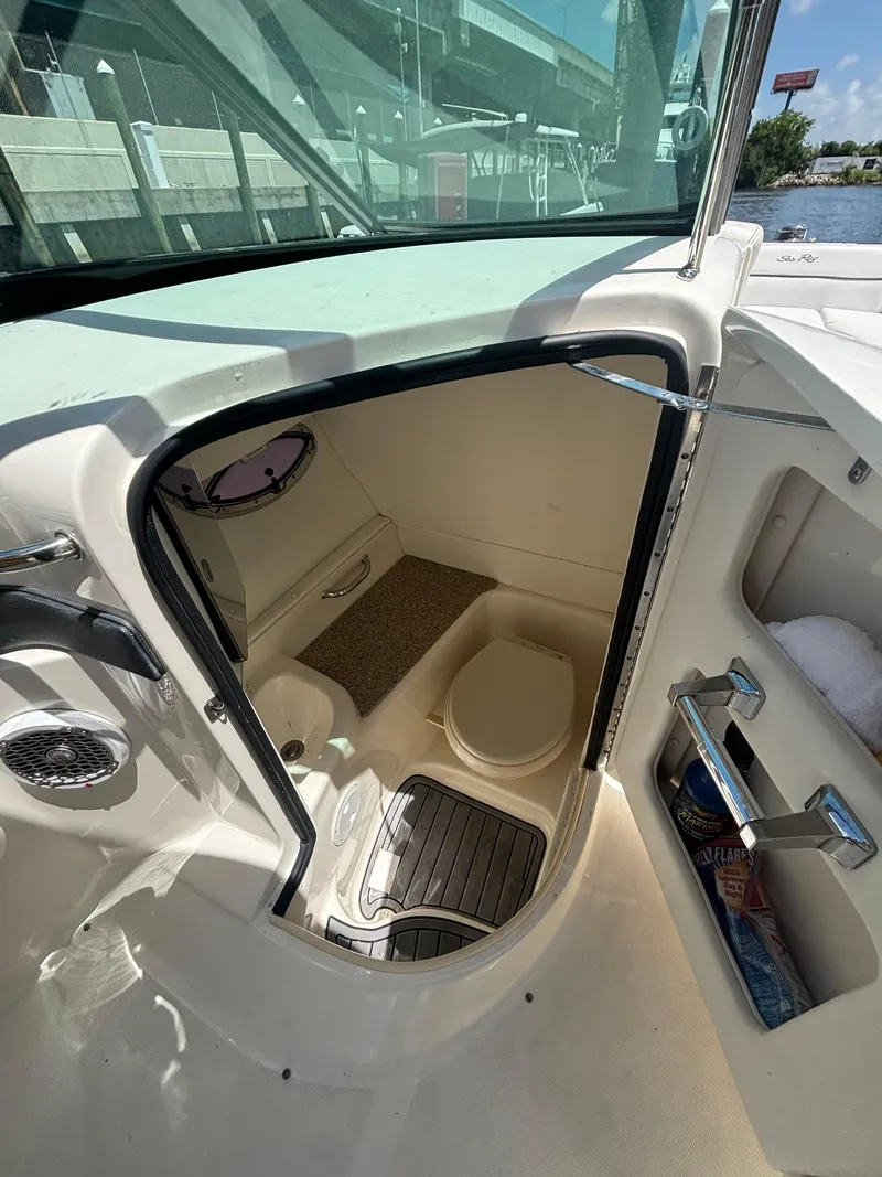 Slide: The Image of 2014 Sea Ray 300 SLX boat interior with compact restroom and storage. - 13