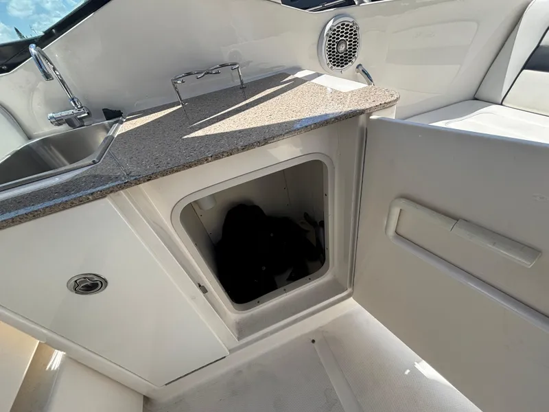 Slide: The Image of 2014 Sea Ray 300 SLX boat interior with sink and storage compartment. - 16