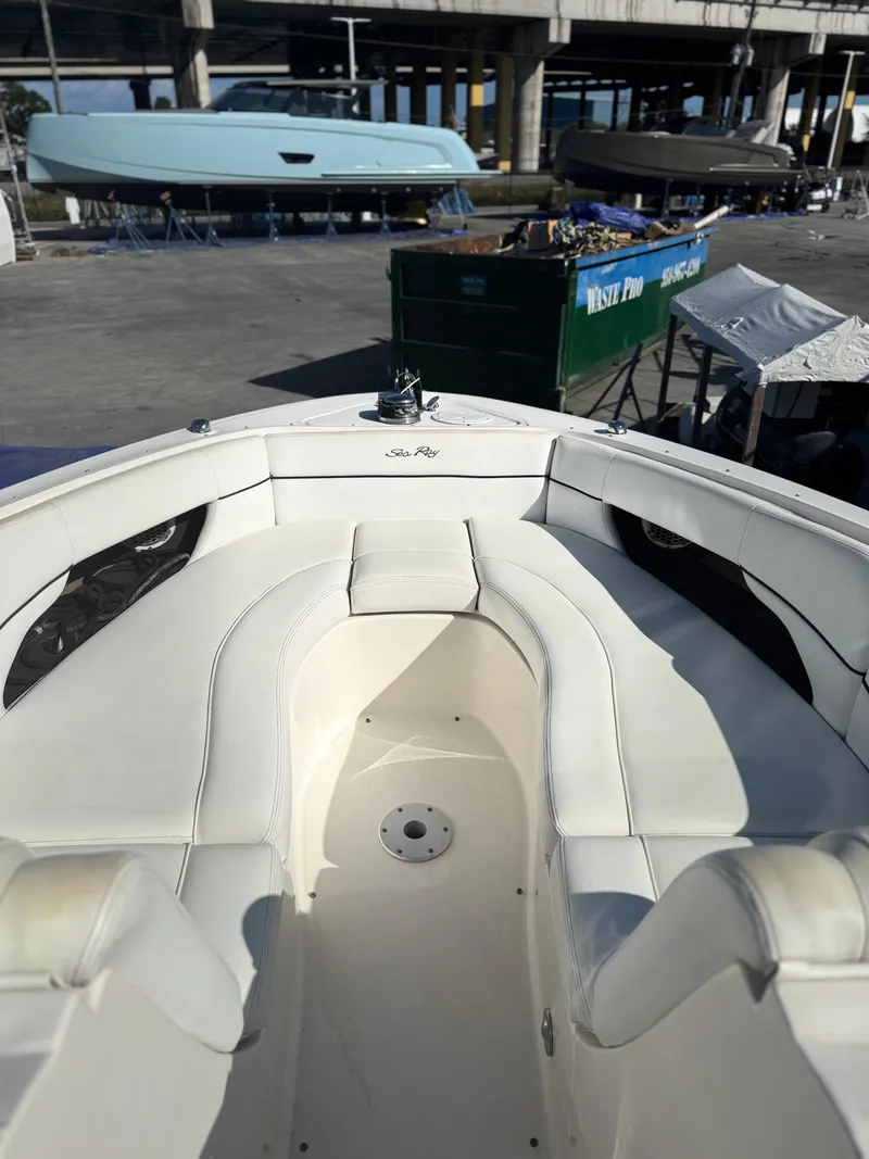Slide: The Image of 2014 Sea Ray 300 SLX boat with white seating, docked near other vessels. - 3
