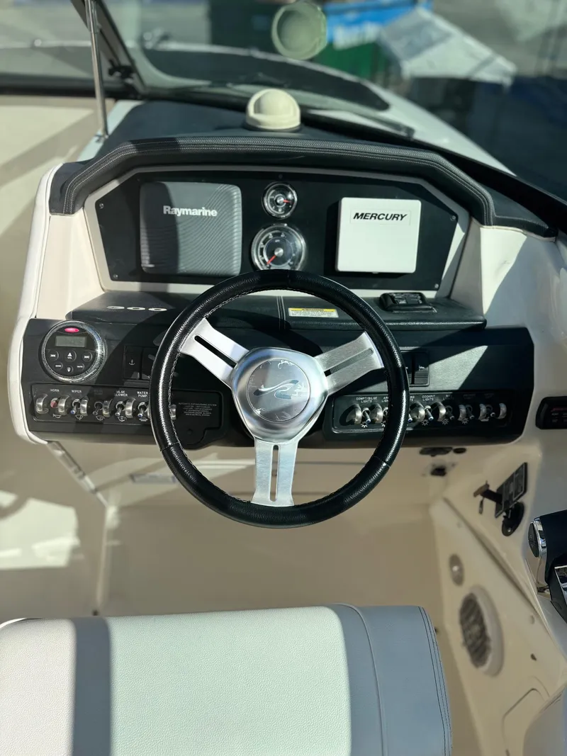 Slide: The Image of Steering wheel and dashboard of 2014 Sea Ray 300 SLX boat, featuring Raymarine and Mercury displays. - 9
