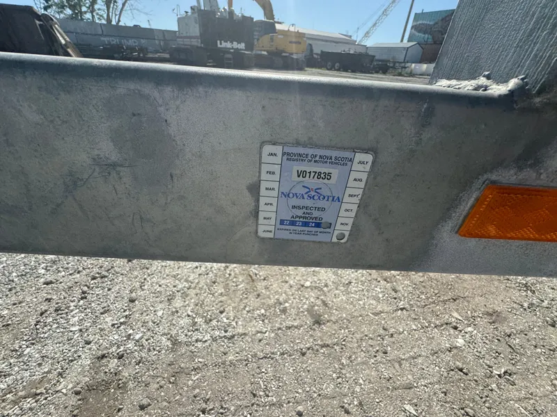 Slide: The Image of Inspection sticker on a trailer, Nova Scotia, gravel lot, industrial background. - 10