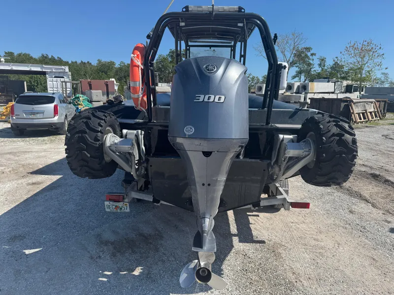 Slide: The Image of Amphibious RIB with Yamaha 300 engine, parked on gravel, featuring large wheels and life preserver. - 12