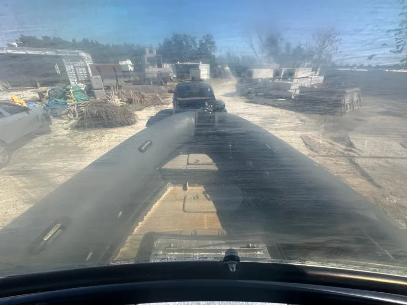 Slide: The Image of Amphibious RIB 30 on land, view from cockpit, surrounded by vehicles and equipment. - 30