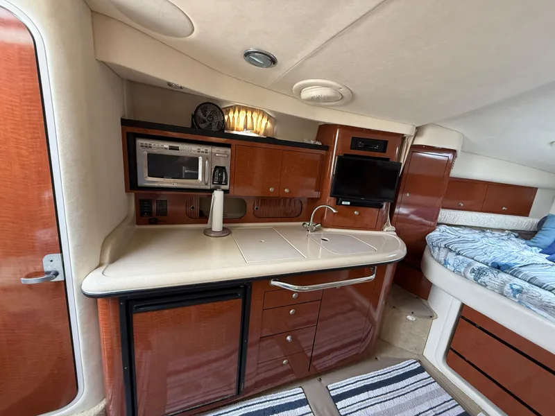 Slide: The Image of Interior of 2005 Sea Ray 340 Sundancer with kitchenette, microwave, and cozy sleeping area. - 17