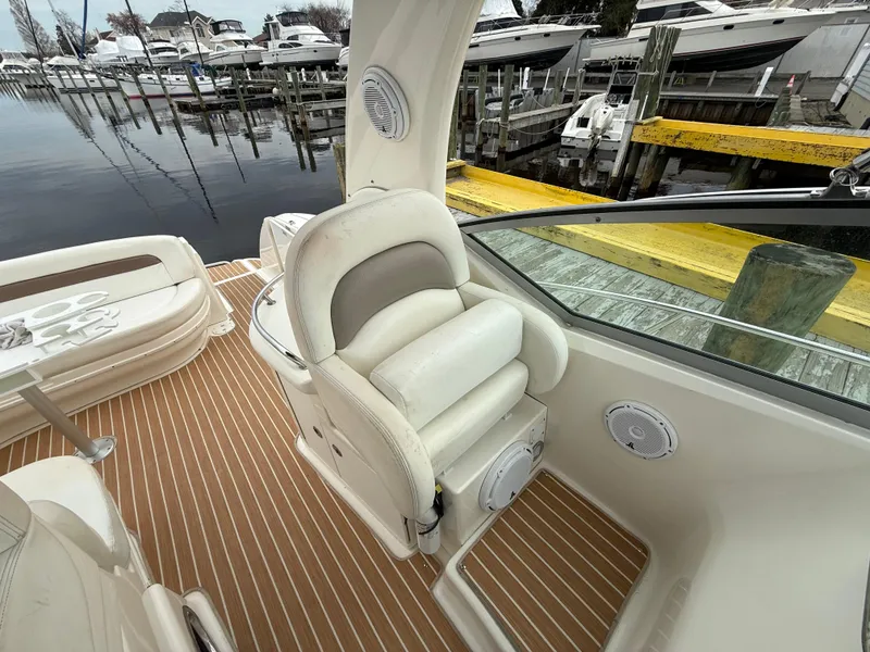 Slide: The Image of 2005 Sea Ray 340 Sundancer cockpit with white seating and wood-patterned flooring at marina. - 28