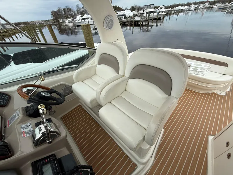 Slide: The Image of 2005 Sea Ray 340 Sundancer cockpit with dual seats and waterfront view. - 31