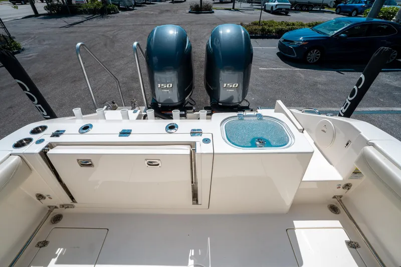 Slide: The Image of 2023 Cobia 240 CC boat with dual Yamaha 150 engines, featuring a clean deck layout. - 10