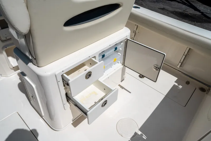 Slide: The Image of 2023 Cobia 240 CC boat interior with open storage compartments and drawers. - 15