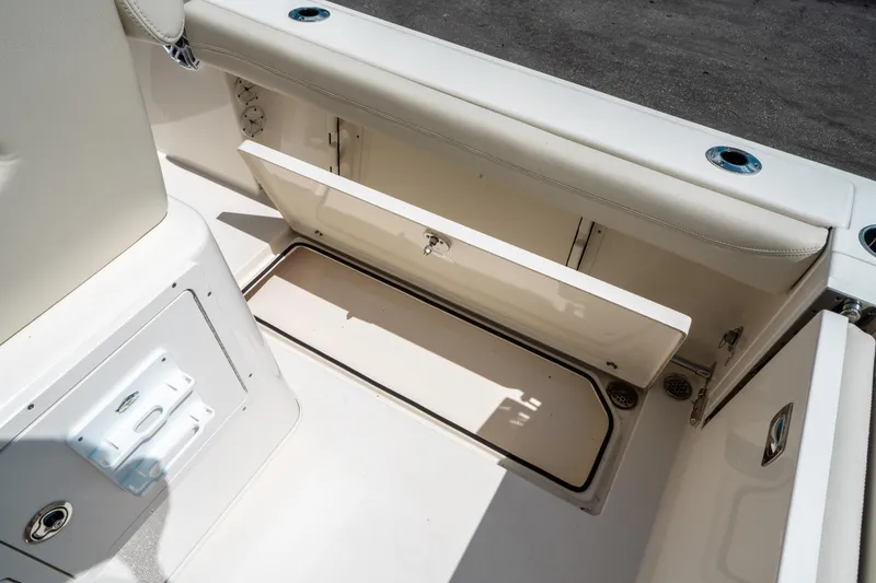 Slide: The Image of 2023 Cobia 240 CC boat storage compartment with open hatch, showcasing interior space. - 17