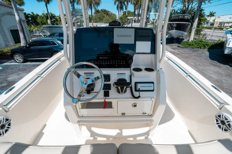 Slide: The Image of 2023 Cobia 240 CC boat dashboard with Garmin navigation system and steering wheel. - 18