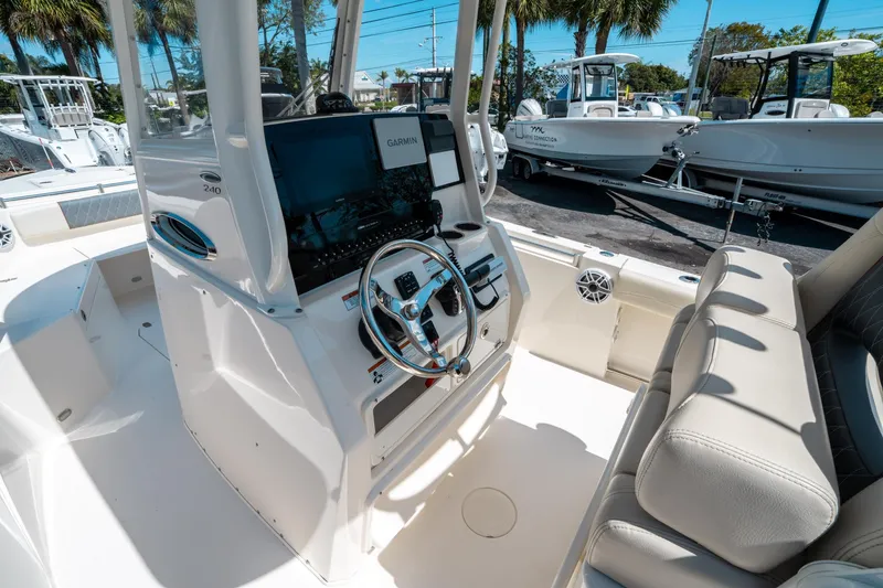 Slide: The Image of 2023 Cobia 240 CC boat interior with steering wheel and Garmin display. - 19