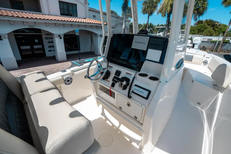 Slide: The Image of 2023 Cobia 240 CC boat cockpit with Garmin navigation system and comfortable seating. - 20