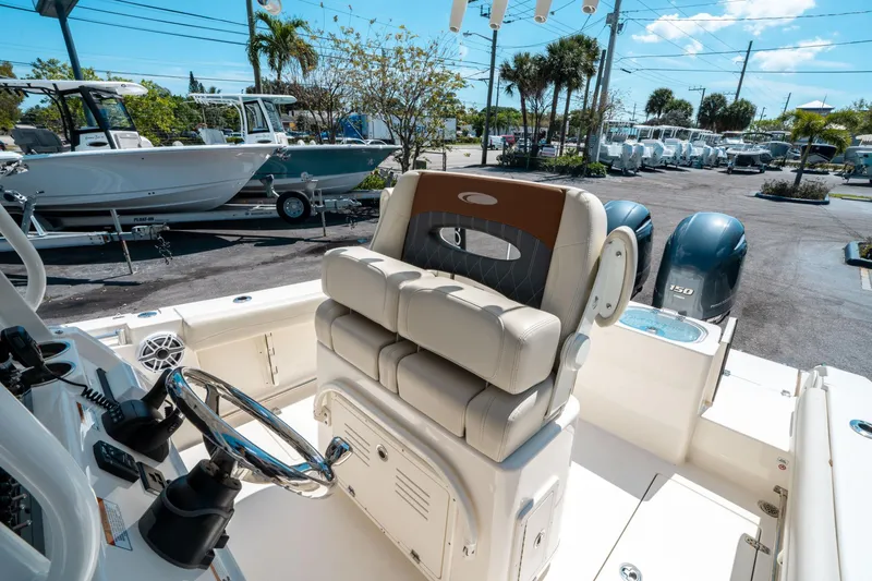 Slide: The Image of 2023 Cobia 240 CC boat interior with dual engines and helm station. - 21
