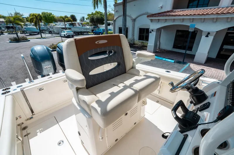 Slide: The Image of 2023 Cobia 240 CC boat interior with helm seat and dual engines. - 23