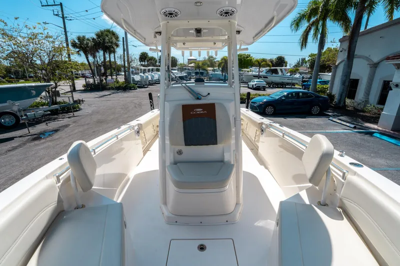 Slide: The Image of 2023 Cobia 240 CC boat interior with seating and console, parked outdoors. - 29