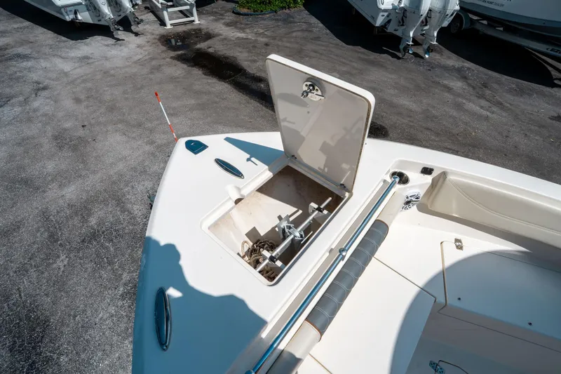 Slide: The Image of 2023 Cobia 240 CC boat anchor storage compartment open on deck. - 37