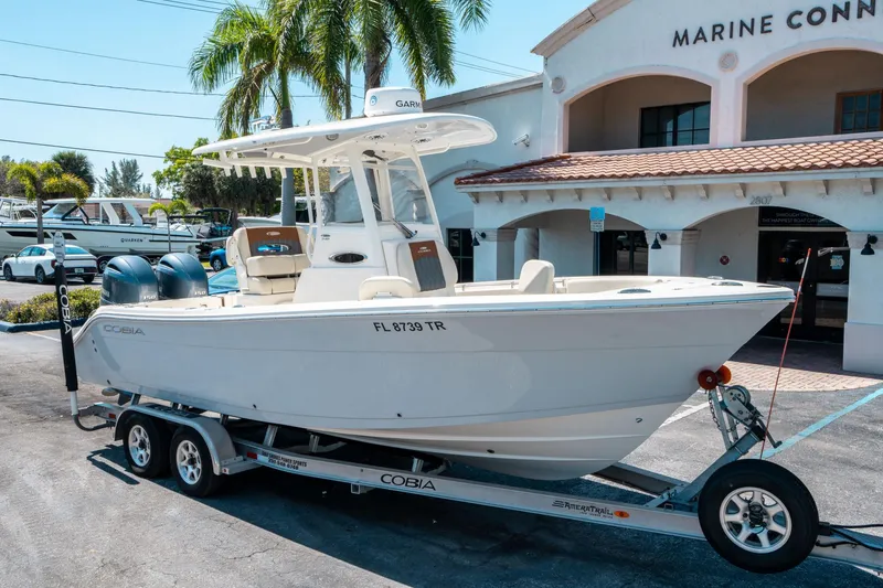 Slide: The Image of 2023 Cobia 240 CC boat on trailer outside Marine Connection dealership. - 8