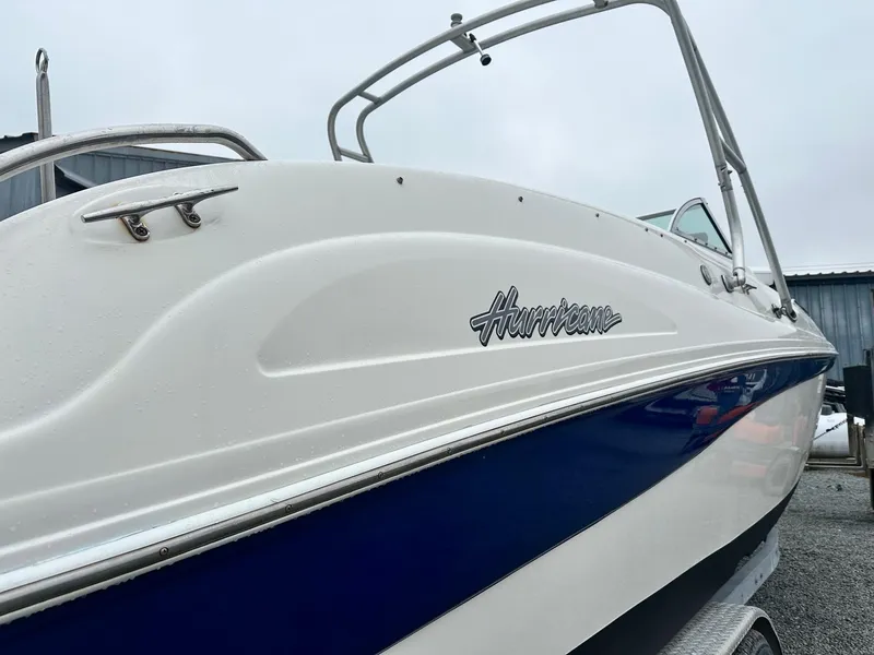 Slide: The Image of 2004 Godfrey Hurricane 260 Sun Deck boat, white and blue exterior, side view. - 1