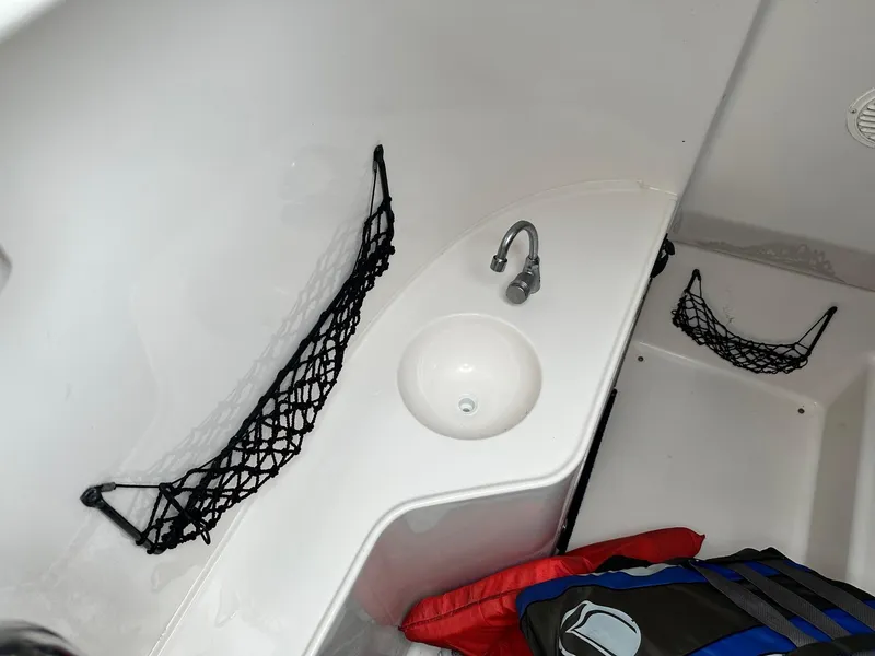 Slide: The Image of 2004 Godfrey Hurricane 260 Sun Deck interior with sink and storage nets. - 13