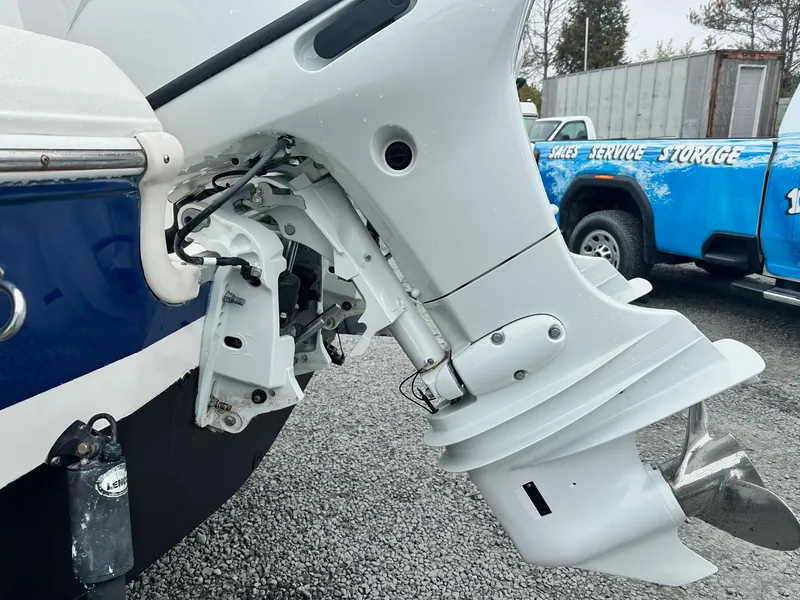 Slide: The Image of 2004 Godfrey Hurricane 260 Sun Deck boat motor, close-up view, parked on gravel. - 5