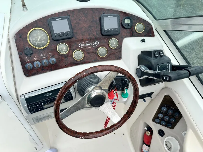 Slide: The Image of 2004 Godfrey Hurricane 260 Sun Deck boat dashboard with steering wheel and control panel. - 8