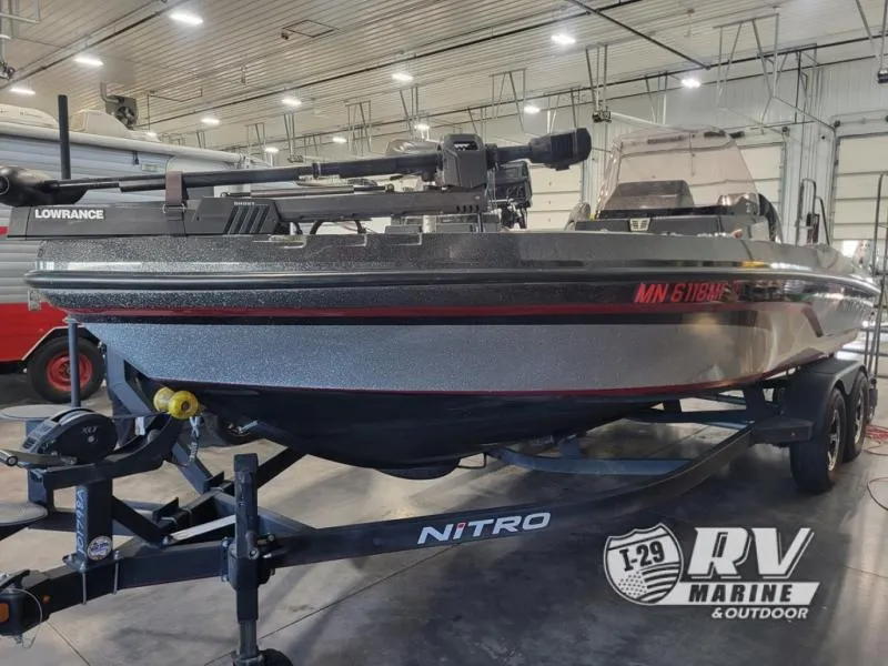 Slide: The Image of 2022 Nitro ZV20 boat in indoor showroom, featuring Lowrance equipment and trailer. - 2
