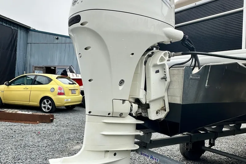 Slide: The Image of 2019 Godfrey Sweetwater 2086C boat motor on trailer, parked near yellow car. - 12