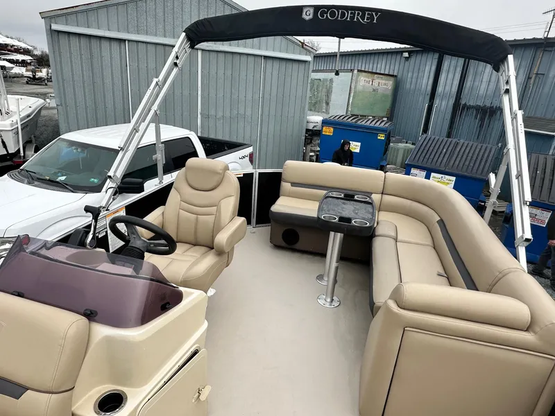 Slide: The Image of 2019 Godfrey Sweetwater 2086C pontoon boat with beige seating and canopy in marina. - 5