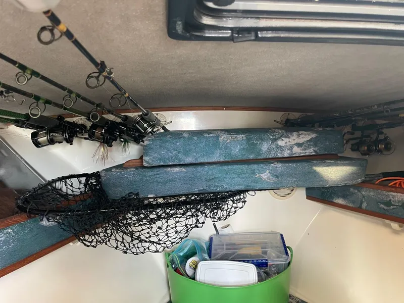 Slide: The Image of Interior of a 2003 Carolina Classic 28 boat with fishing gear and storage. - 17