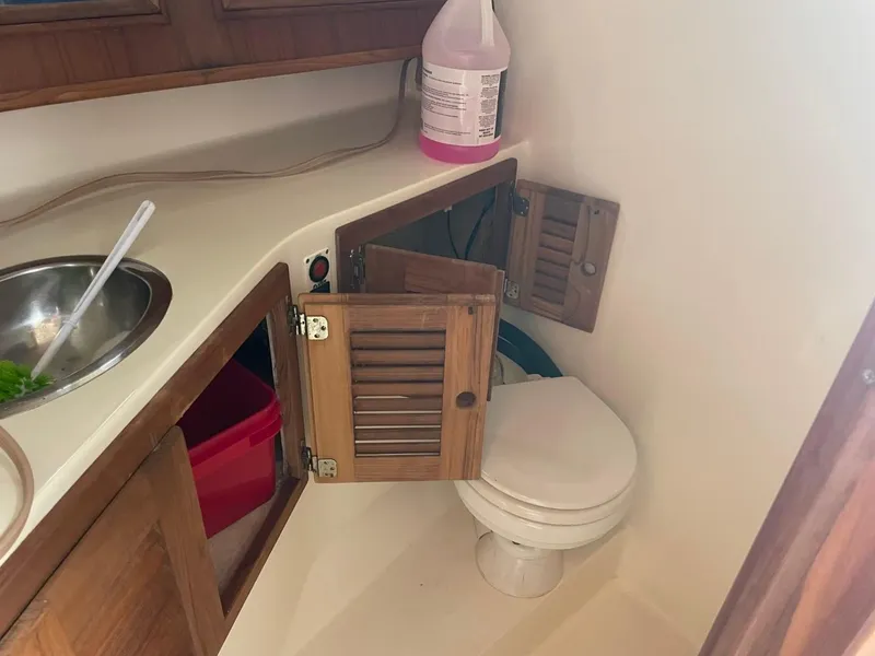 Slide: The Image of 2003 Carolina Classic 28 boat interior with sink, cabinets, and toilet. - 18