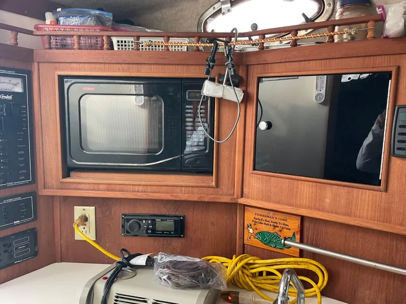 Slide: The Image of 2003 Carolina Classic 28 boat interior with microwave, storage, and electronic equipment. - 19