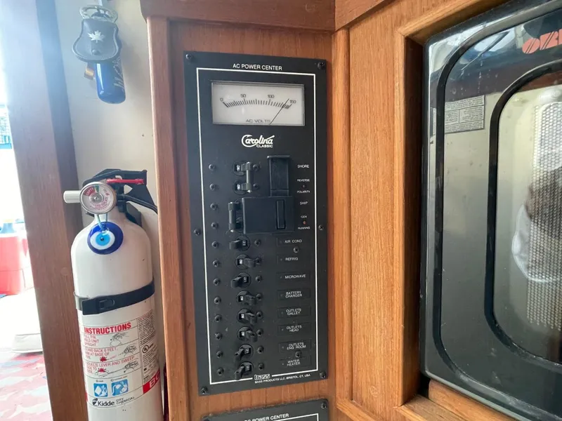 Slide: The Image of AC power control panel in a 2003 Carolina Classic 28 boat interior. - 21