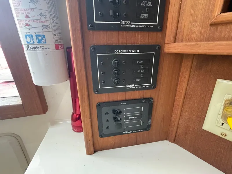 Slide: The Image of Control panel in a 2003 Carolina Classic 28 boat cabin, featuring switches and a fire extinguisher. - 22